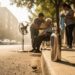 People providing shade and cooling while staying hydrated on a very hot urban street during an extreme temperature warning.