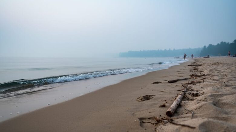 “Hazy Sauble Beach shoreline with muted colors and reduced visibility over the water from wildfire smoke.”
