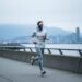Runner jogging along Vancouver’s seawall with coastal haze and a cool gray skyline suggesting changing air quality conditions.