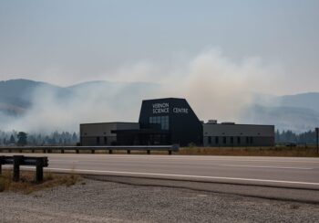 Vernon Science Centre in the BC Interior with light wildfire smoke drifting across the Okanagan Valley under overcast light, suggesting changing air quality conditions influenced by wind.